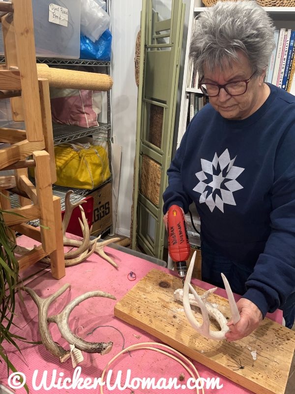 Cathryn Peters in her studio, drilling deer antlers for weaving her antler basket sculptures.