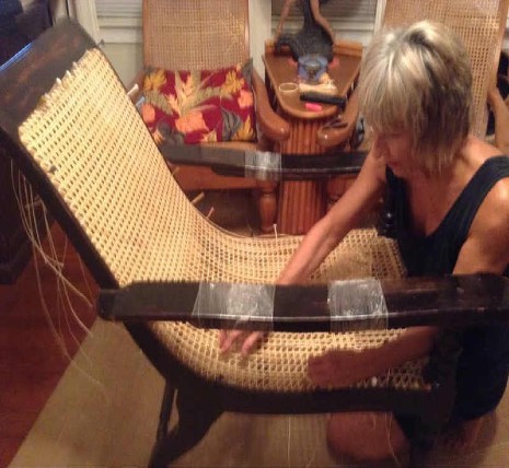 Sandra Rosar, owner of Den of Antiquity in Florida is repairing the seat of a Plantation chair for a customer. 
