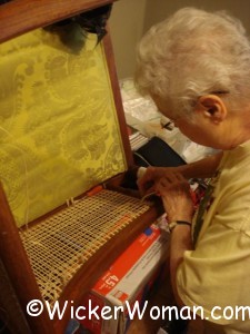 Jan Noall, master seatweaver from Ohio, blind caning a large upholstered chair arm. 