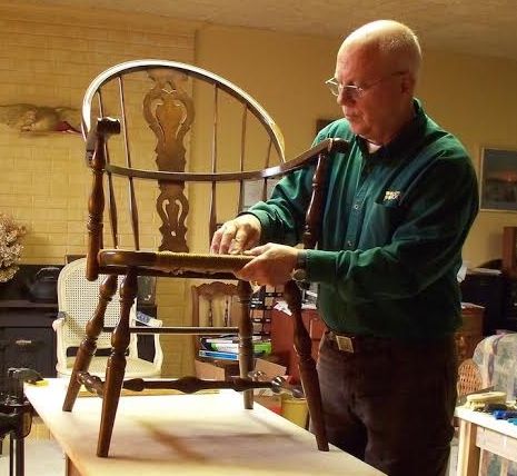 Dick Knotts, owner of The Seat Doktor in Vernon, CT, weaving a rush seat in a Windsor chair.  