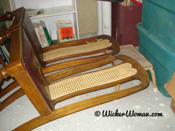 Two cane webbing back chairs are laying horizontally until the glue in the grooves dries and the caning is dry, too. 