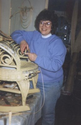 Cathryn Peters, antique wicker repair expert, restoring a Victorian ram's horn wicker rocker.