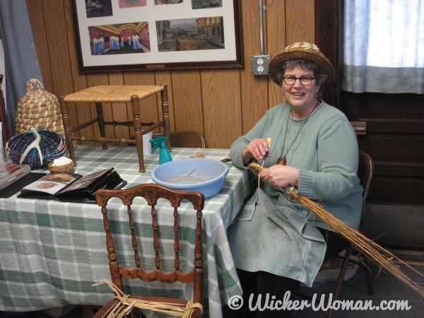 Cathryn Peters demonstrating weaving a coiled bee skep.