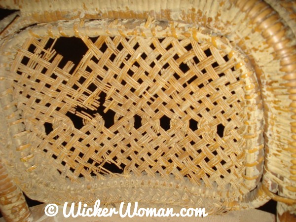 Close-up of detailed esparto grass woven design under arms
 of this Victorian wicker rocker