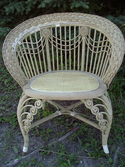 Fully repaired Victorian fancy wicker posing chair with a set-in close woven cane webbing seat, curlicues, swag decorations on the back with swooping arms and back. 