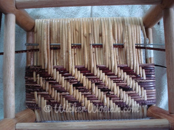Bottom of wide binding cane footstool, showing the 3x3 twill pattern, using a caning needle.